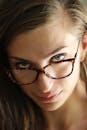这是一张戴眼镜的自信女性的特写照，展现了她迷人的目光
