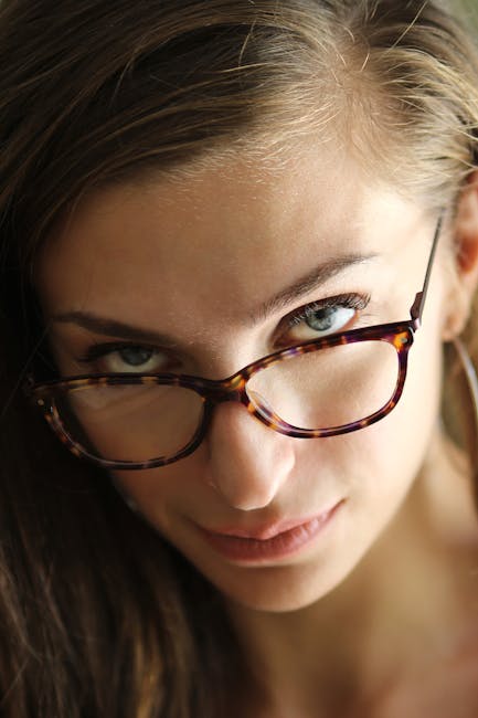 Close-up portrait of a confident woman wearing eyeglasses, showcasing her captivating gaze.