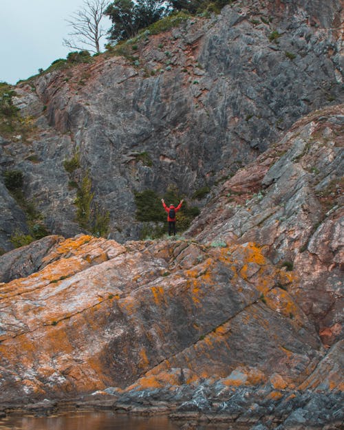 Person Waving on Top of Dry Terrain Mountain