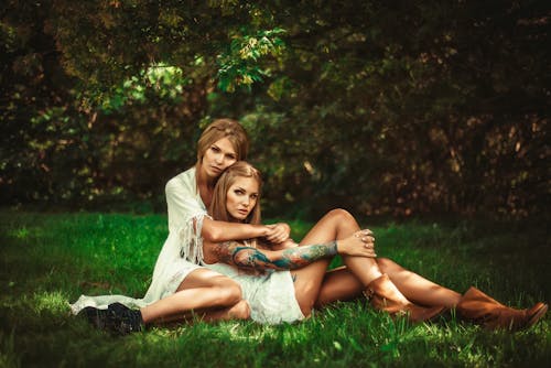 Foto Von Zwei Frauen, Die Auf Gras Sitzen