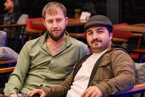 Free Two friends enjoying a relaxed evening at a cozy restaurant with warm ambiance. Stock Photo