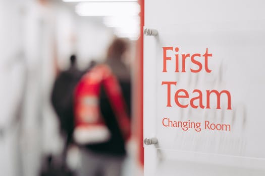 Blurry image of a sports team changing room sign with people in the background.