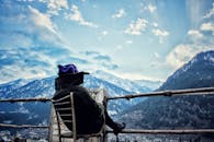 一个身着冬装的人，正欣赏着白雪皑皑的山脉间那份宁静的景色