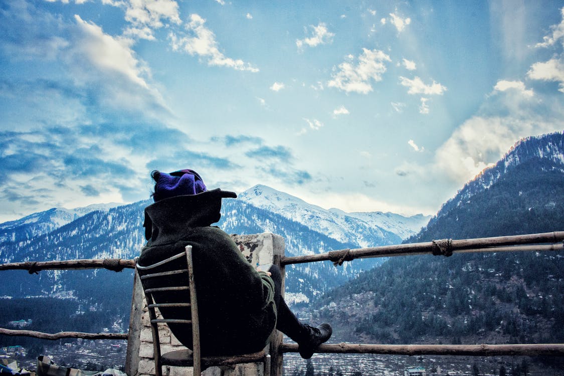 Personne Assise Chaise Blanche Lors De La Lecture En Face De Paysages De Montagne