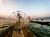 黎明时分，渔民们用传统技术在平静的湖面上劳作，勾勒出一片宁静的文化景观