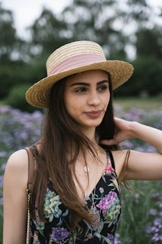 英国剑桥花田中，一位年轻女子身着花裙、头戴太阳帽的肖像