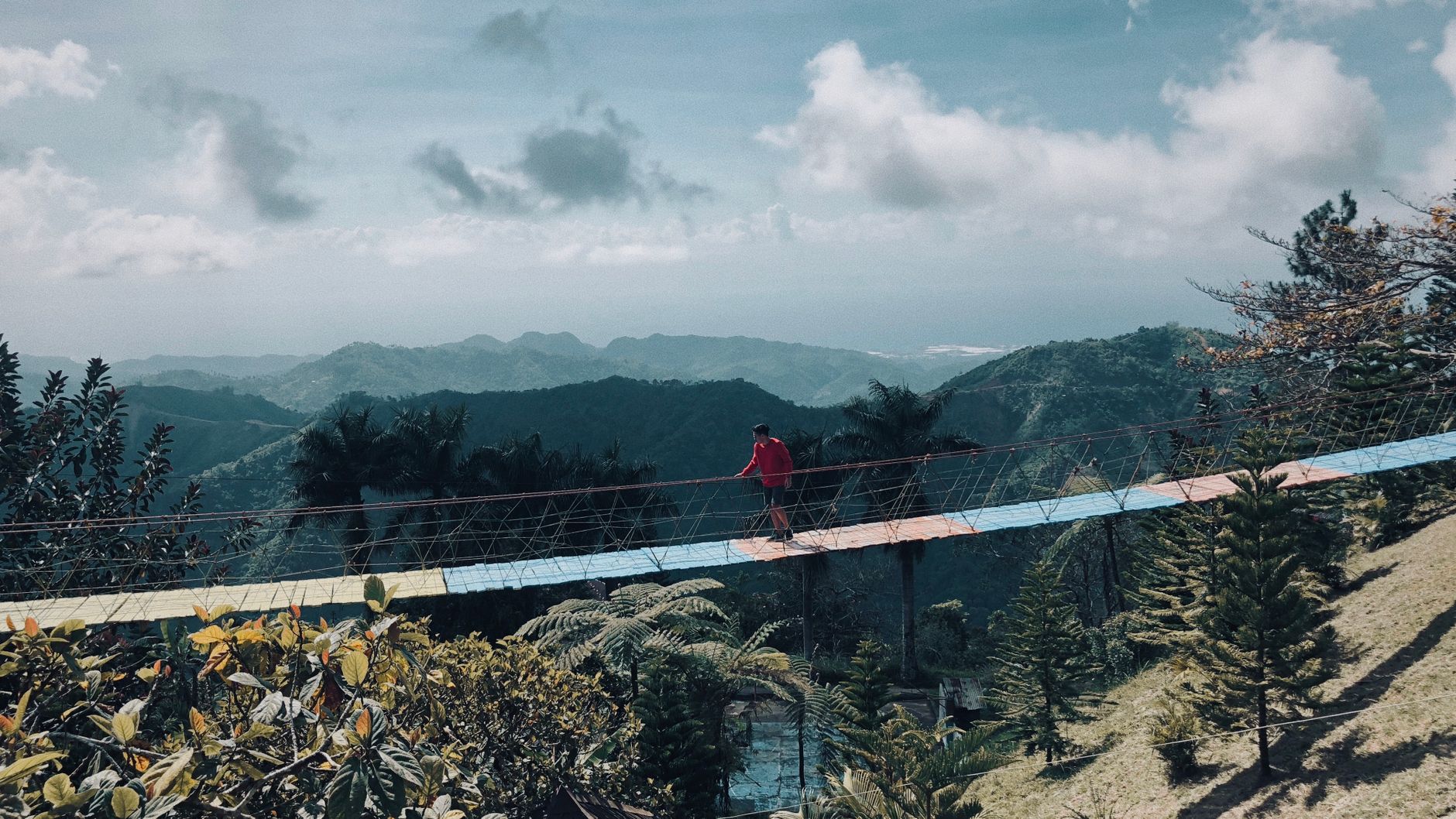 Wisatawan berjalan di atas ciwidey jembatan rengganis dengan latar pemandangan lembah hijau yang luas Wisatawan berjalan di atas ciwidey jembatan rengganis dengan latar pemandangan lembah hijau yang luas