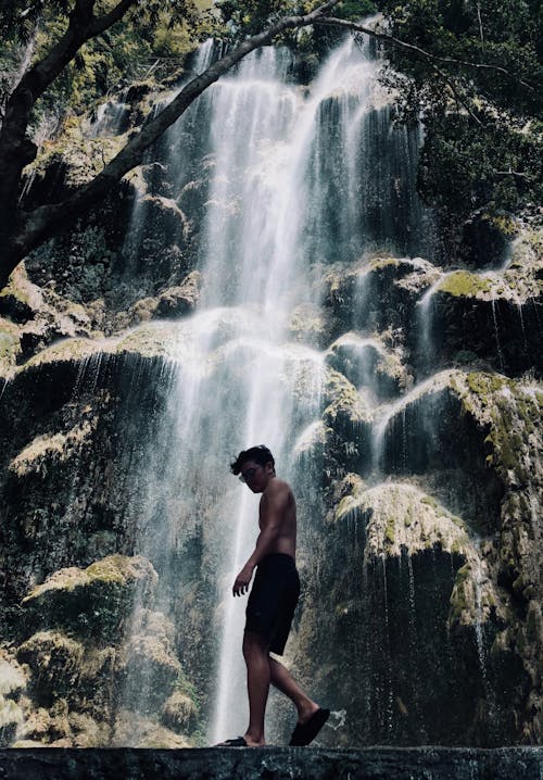 Free Man Standing Near Waterfall Stock Photo