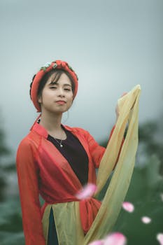 一位身着传统服装的亚洲女性在户外优雅地摆出肖像，表情宁静