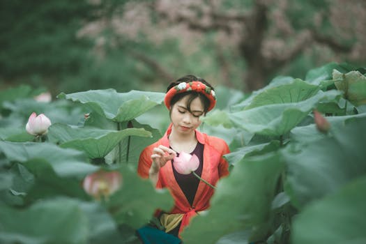 一位年轻亚洲女子的宁静肖像，她在郁郁葱葱的莲花丛中平和地拥抱大自然