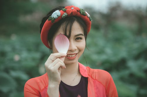 Woman Holding a Pink and White Flower Petal