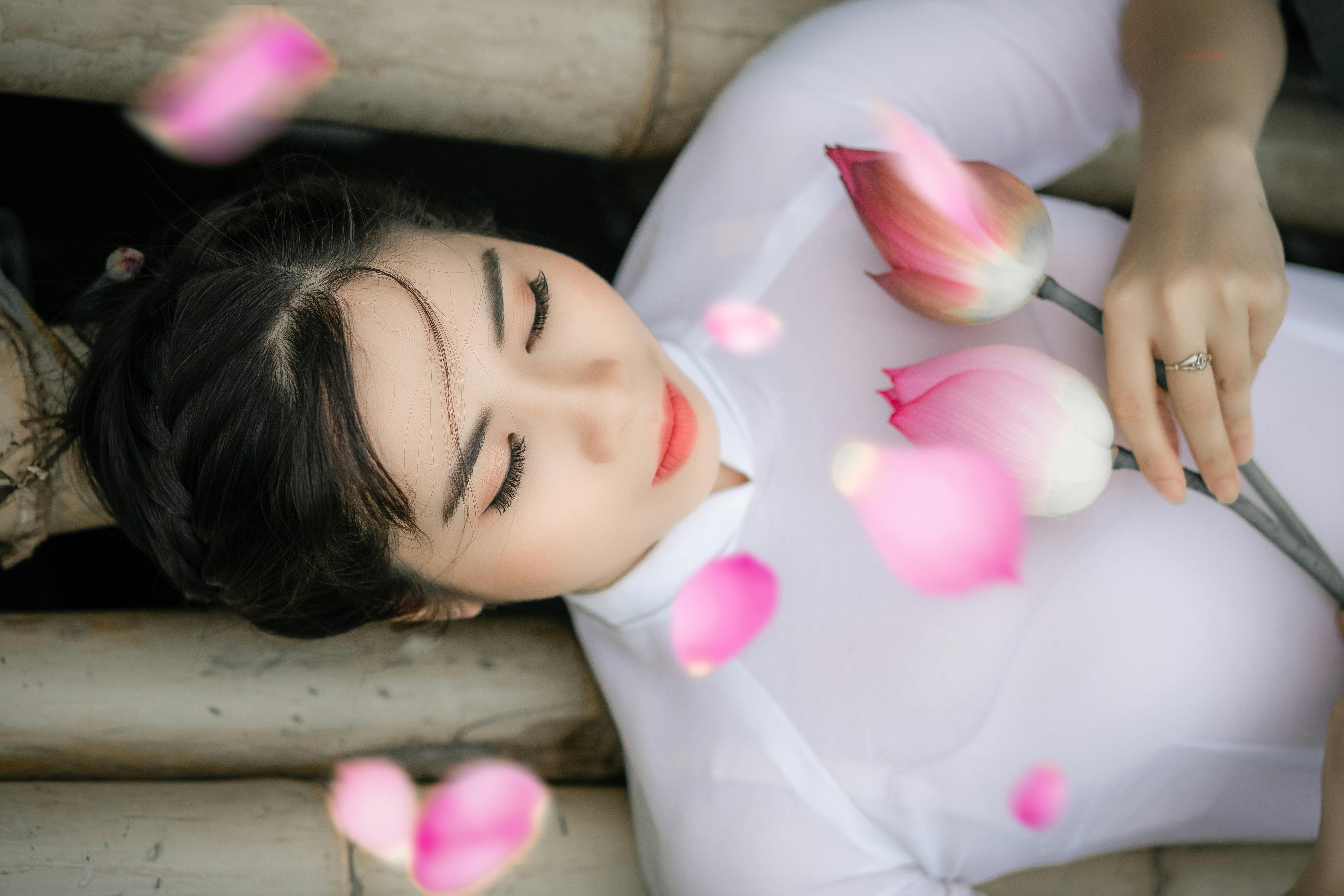 woman holding two pink petaled flowers