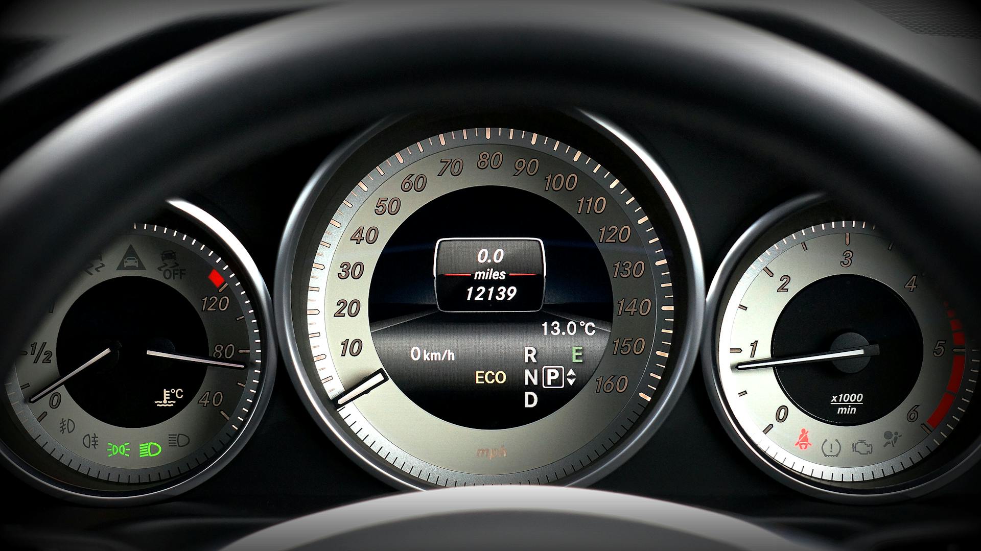 Close-up image of a car dashboard highlighting speedometer, odometer, and temperature gauge.