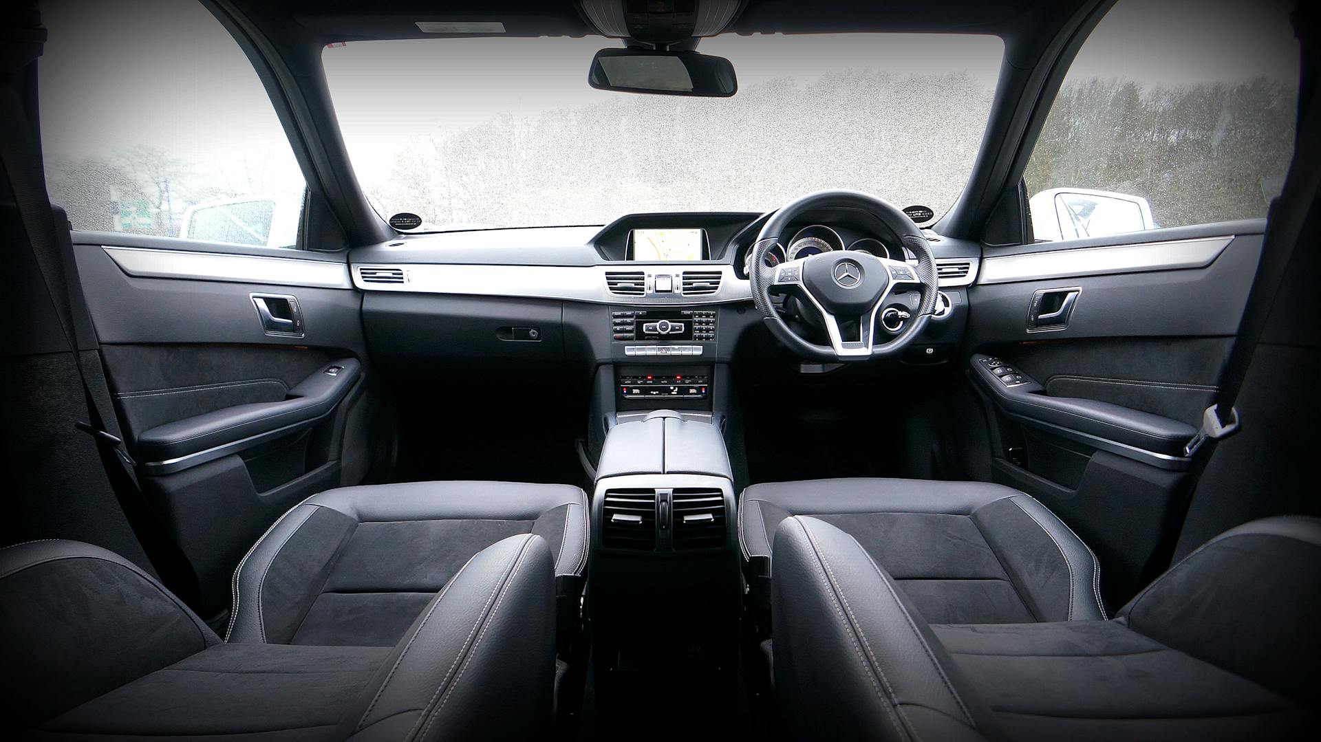 Explore the luxurious interior of a modern car featuring a sleek dashboard and leather seats.