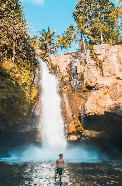Man Standing Near Waterfalls