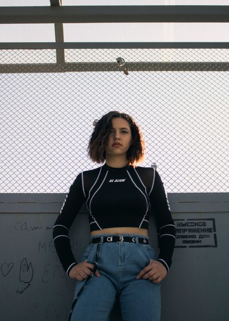 Portrait of a woman in a black top and denim jeans, exuding urban fashion vibes.