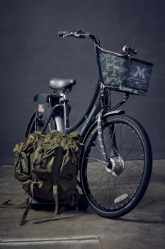 Bicycle with military-style backpack on pavement in an urban setting.
