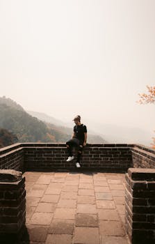 在中国长城云雾缭绕的景色中，一个人享受着宁静的时刻