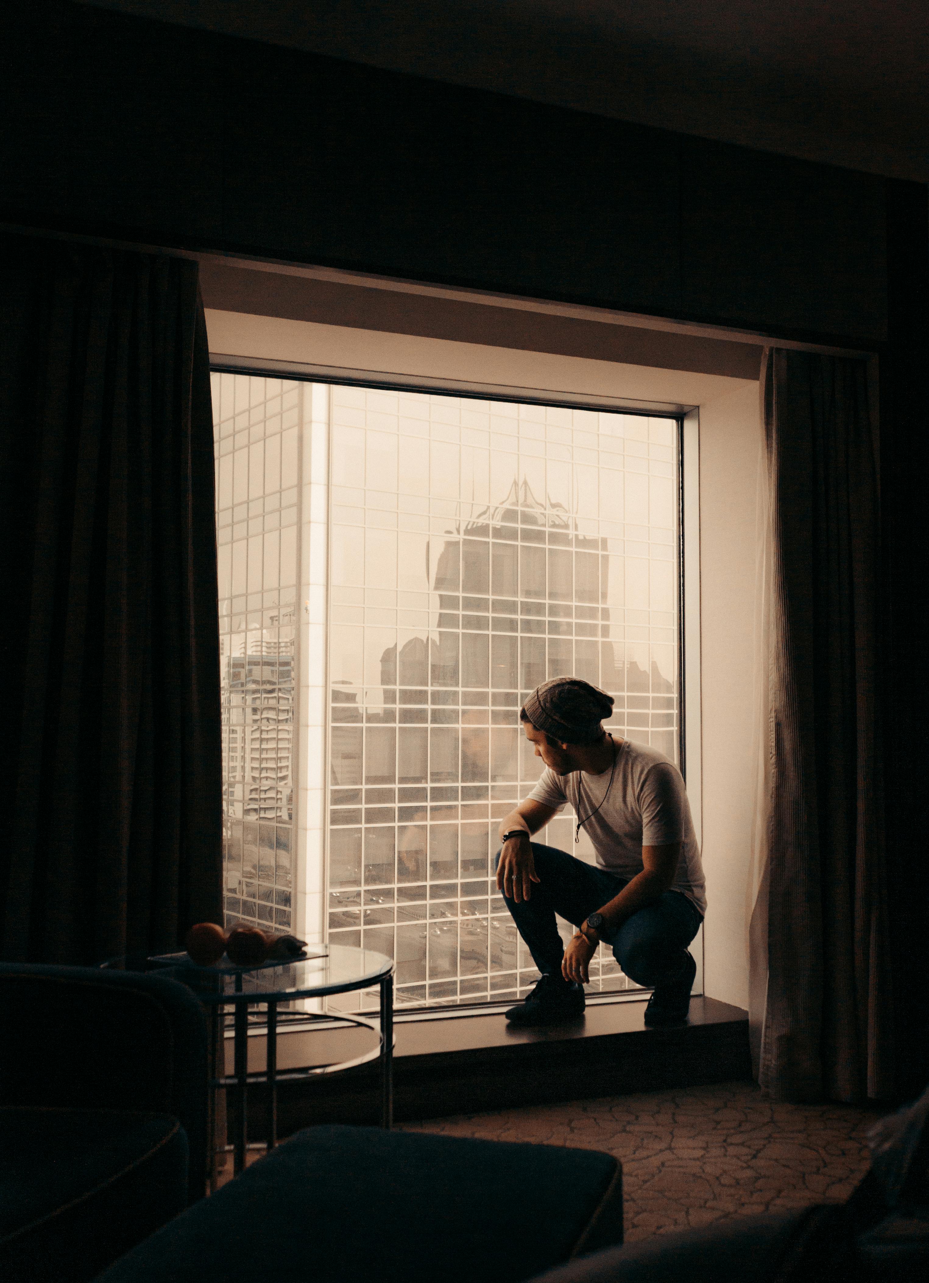 Man Sitting Near Glass Window · Free Stock Photo