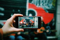 街头音乐家用智能手机摄像头捕捉到自己在城市环境中演奏吉他的画面