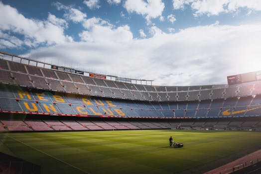 A vibrant football stadium with a well-maintained grass field under a bright sky, showcasing its iconic architecture.