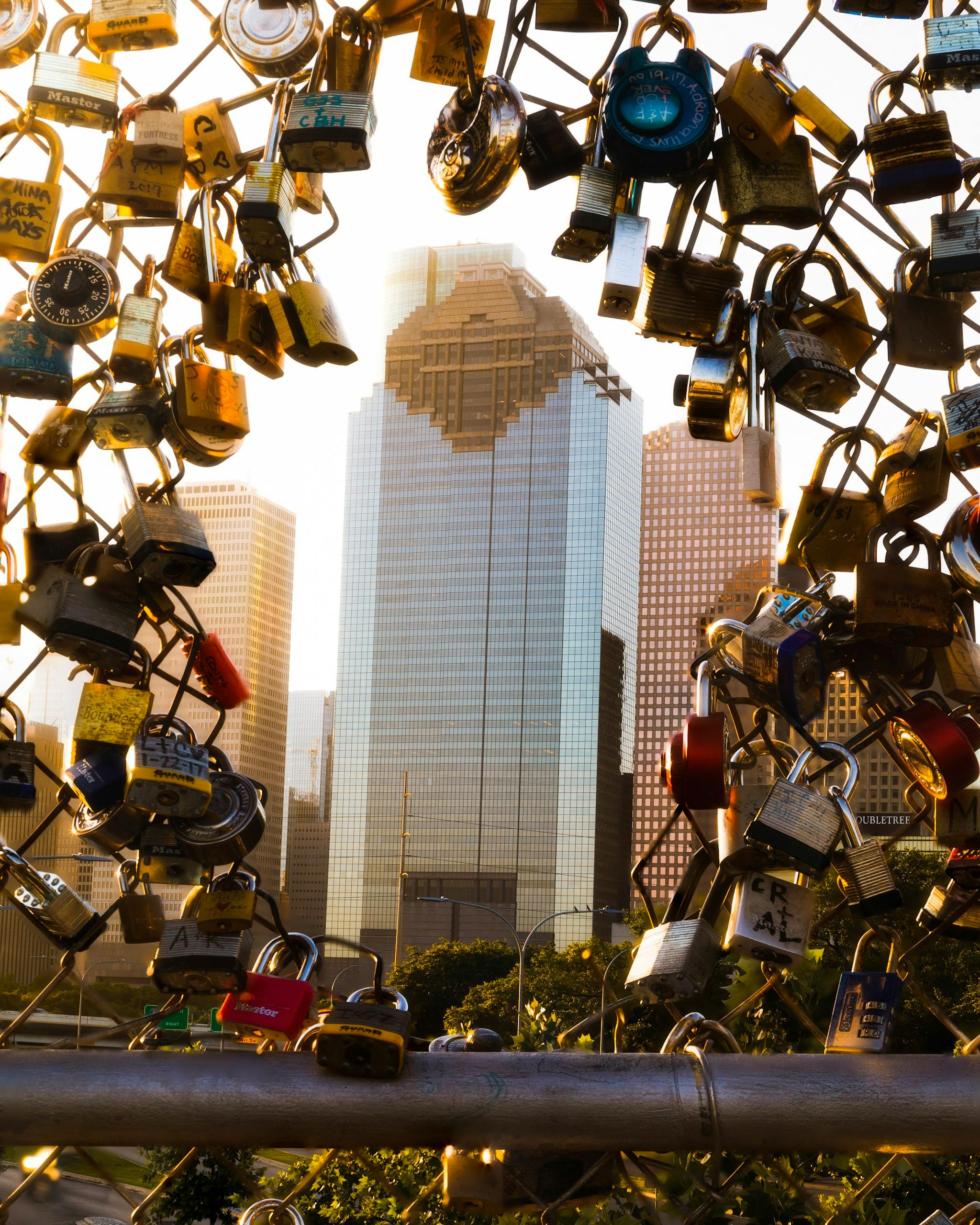 日出时分拍摄的照片中，现代休斯顿摩天大楼被栅栏上的挂锁包围