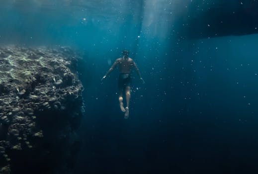 潜水员潜入水下，探索充满活力的珊瑚礁，捕捉海洋的宁静与神秘