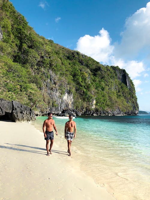 Dos Hombres Caminando Por La Orilla