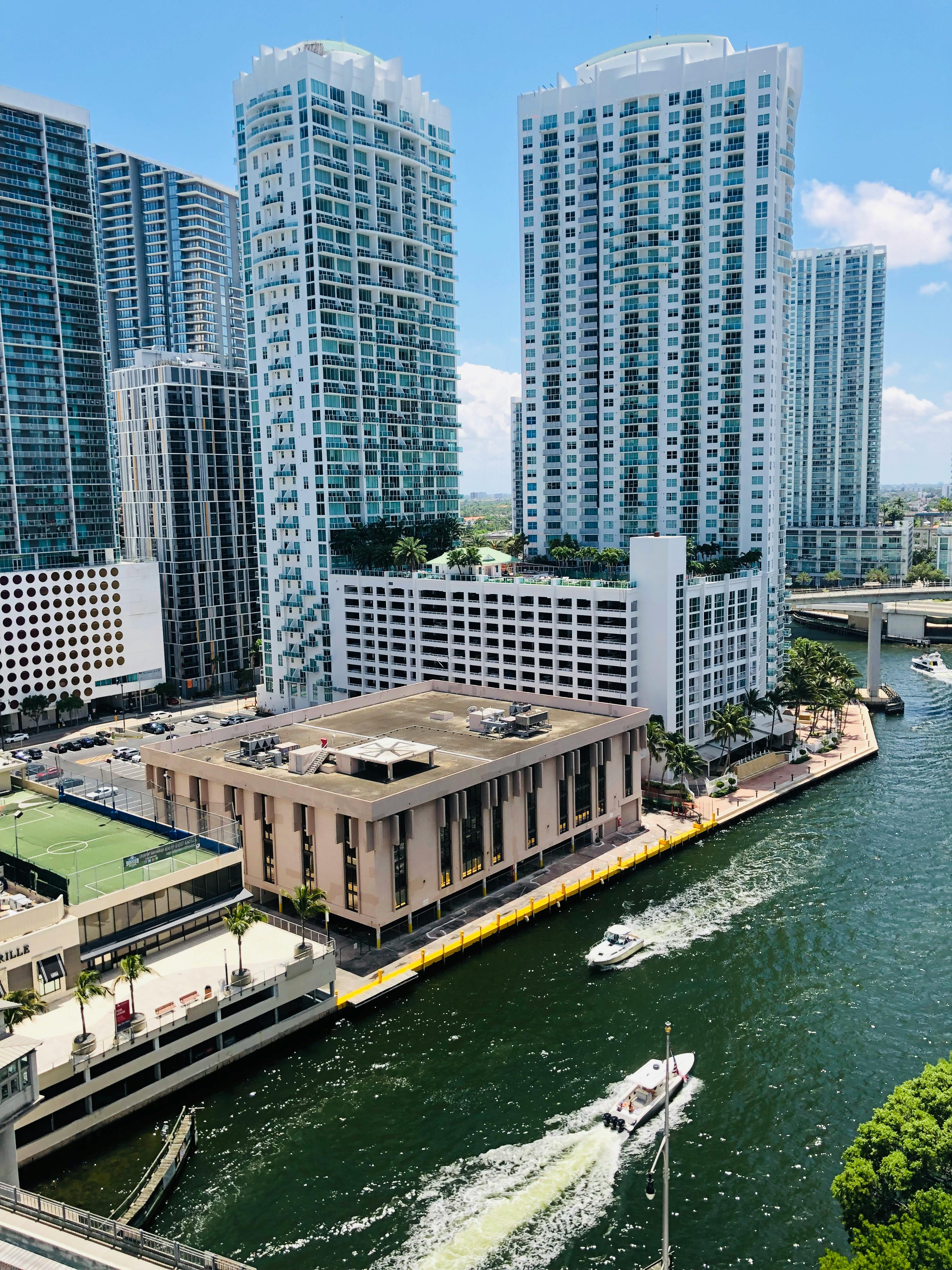 photo of motorboats on river near buildings