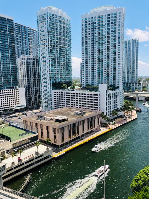 Free Aerial view of modern skyscrapers by a lively waterfront in a vibrant city. Stock Photo