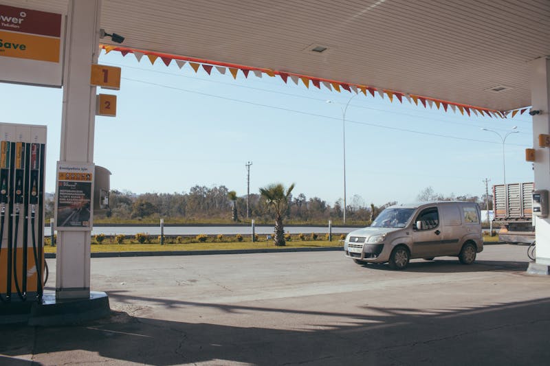 A van parked at a roadside gas station under a clear blue sky.