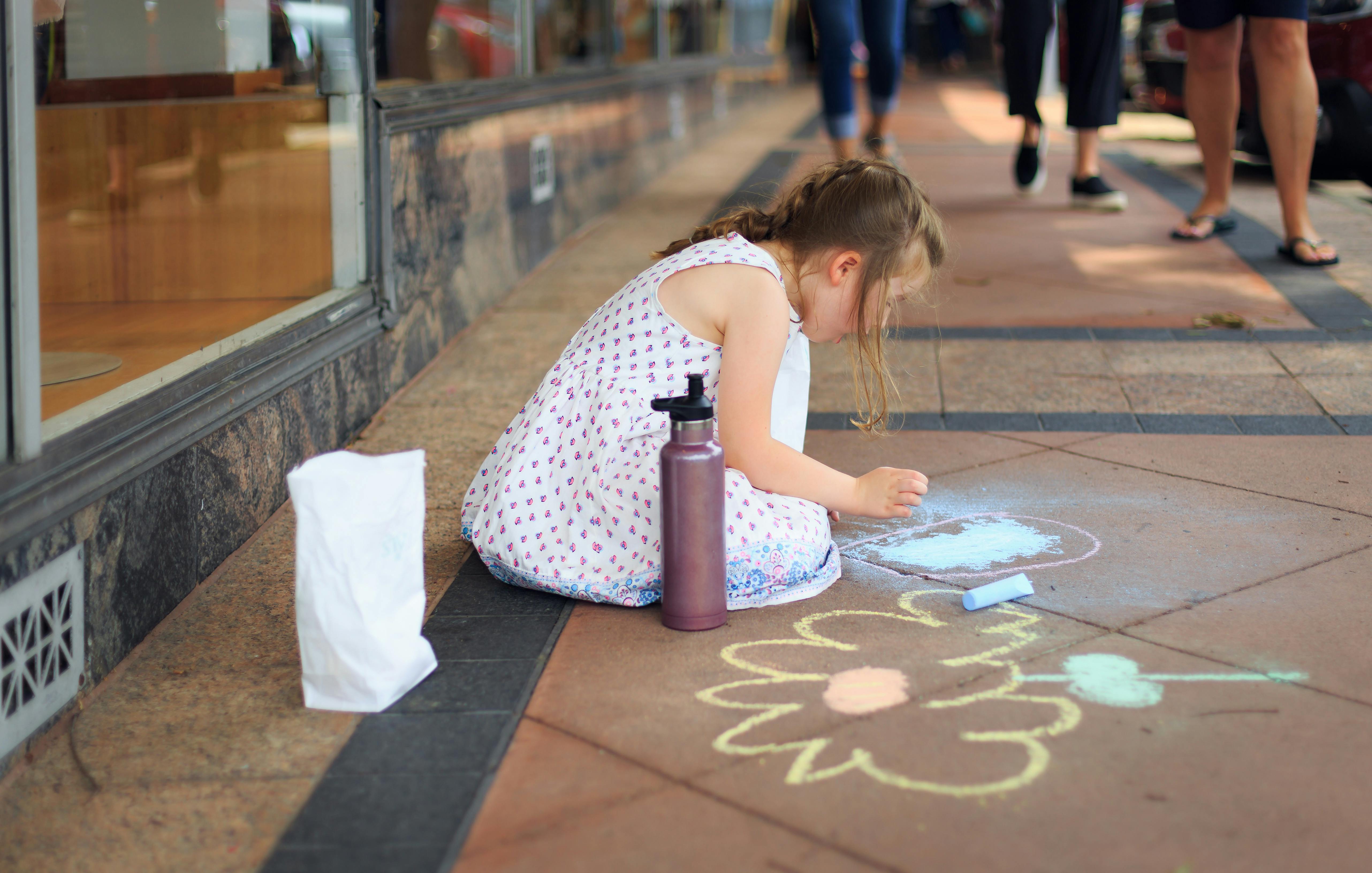 Girl Drawing on the Floor Using Chalks · Free Stock Photo