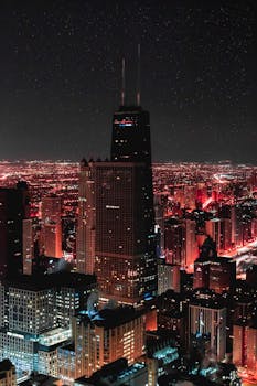 Bright city lights illuminate the Chicago skyline under a starry night.