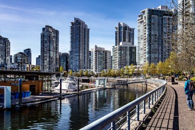 Downtown Vancouver is the city's bustling heart, encompassing vibrant neighborhoods like Yaletown, West End, and Coal Harbour. The image might showcase the sleek skyscrapers of Coal Harbour set against the backdrop of the shimmering Burrard Inlet and Stanley Park. Yaletown could be represented by its chic waterfront vibe, historic redbrick buildings, and trendy restaurants, while the West End offers a mix of modern condos and charming heritage homes nestled near lush parks and the famous English Bay beaches. Together, these areas create a dynamic urban core with a perfect balance of natural beauty, luxury living, and vibrant culture.