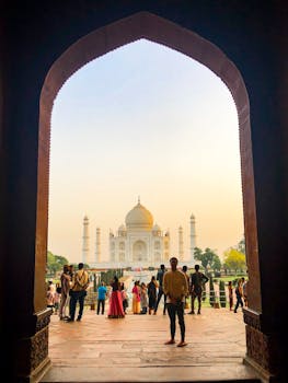 日落时分，游客们在印度阿格拉欣赏着拱门环绕的雄伟泰姬陵