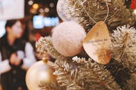 在温暖的室内环境中，松树上的圣诞装饰品特写，带有节日气息