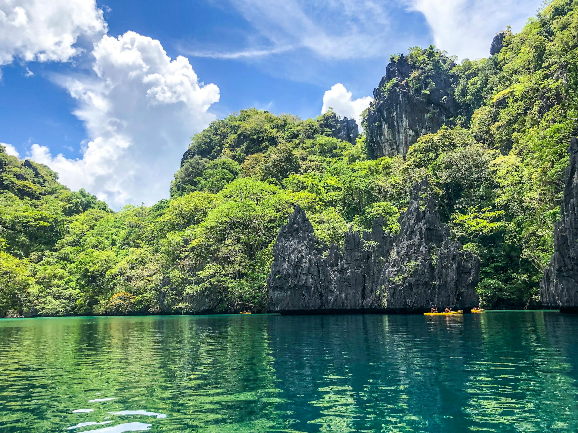 Explore this serene tropical lagoon with clear turquoise waters and lush limestone cliffs.