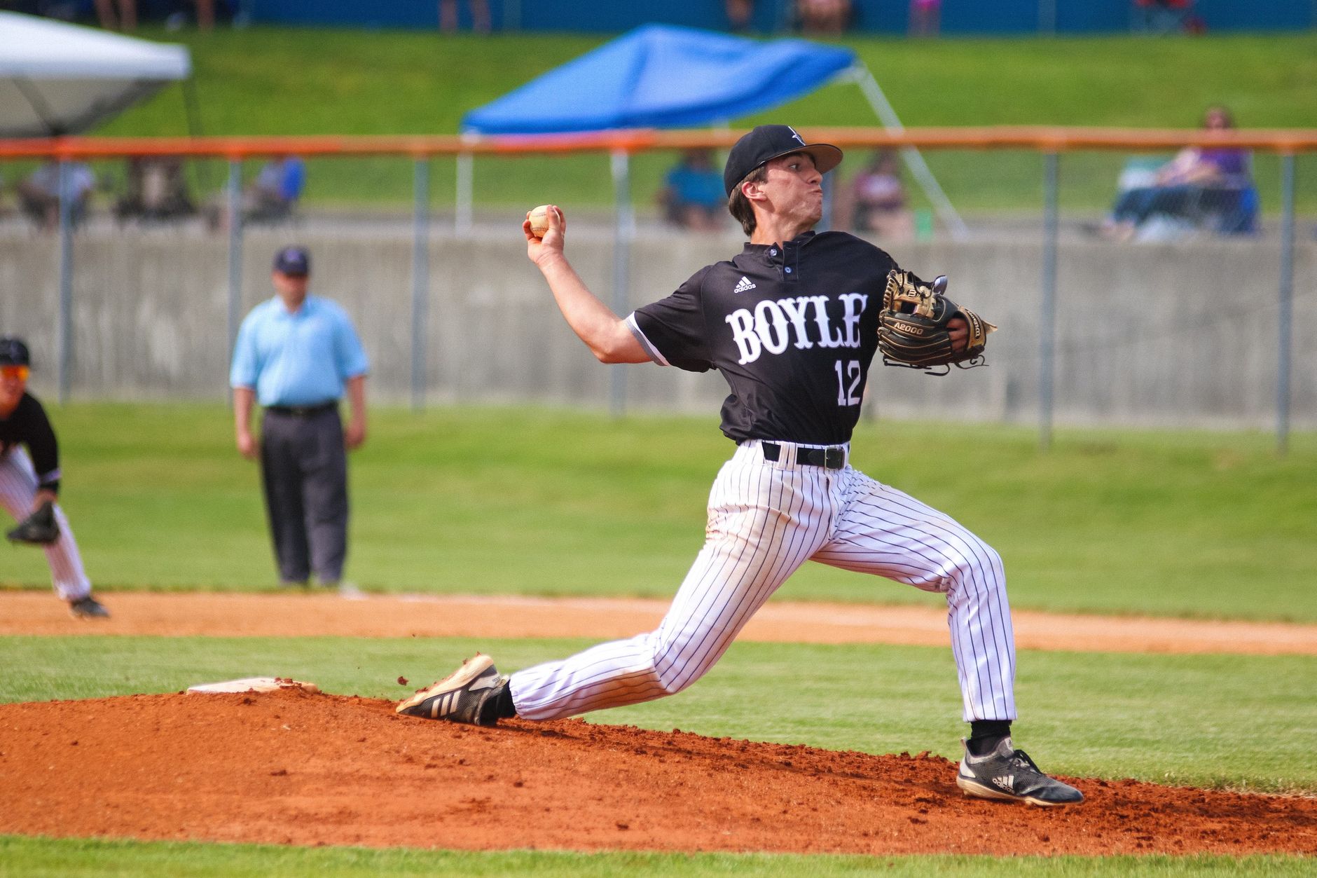 Dynamic shot of a baseball pitcher mid-throw during a daytime game.