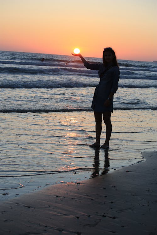 女人站在海邊的照片