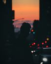 纽约市街道上，一个人的剪影映衬在充满活力的日落色彩背景中