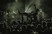 一张黑白照片戏剧性地展现了音乐会现场，舞台灯光下歌迷拥挤的场景