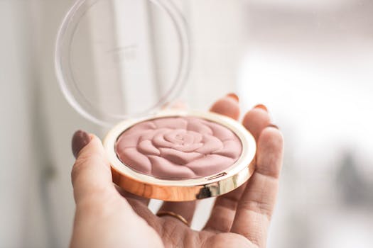 A delicate rose-shaped blush compact held in hand, perfect for enhancing your makeup collection.