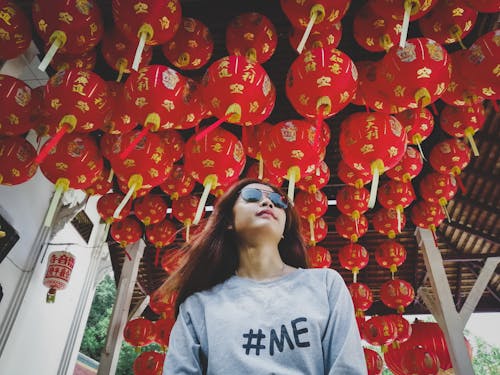 Low Angle Photo of Woman in Sunglasses Under Red Chinese Lantern