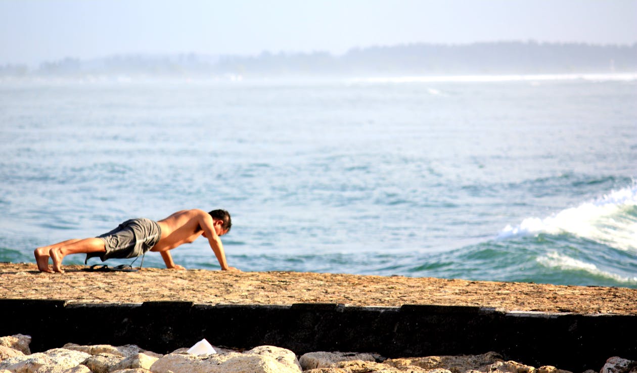 Man Doing Push Up on the Seashore