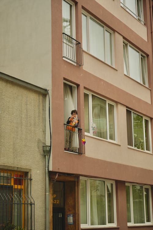 A man is standing on the balcony of a building