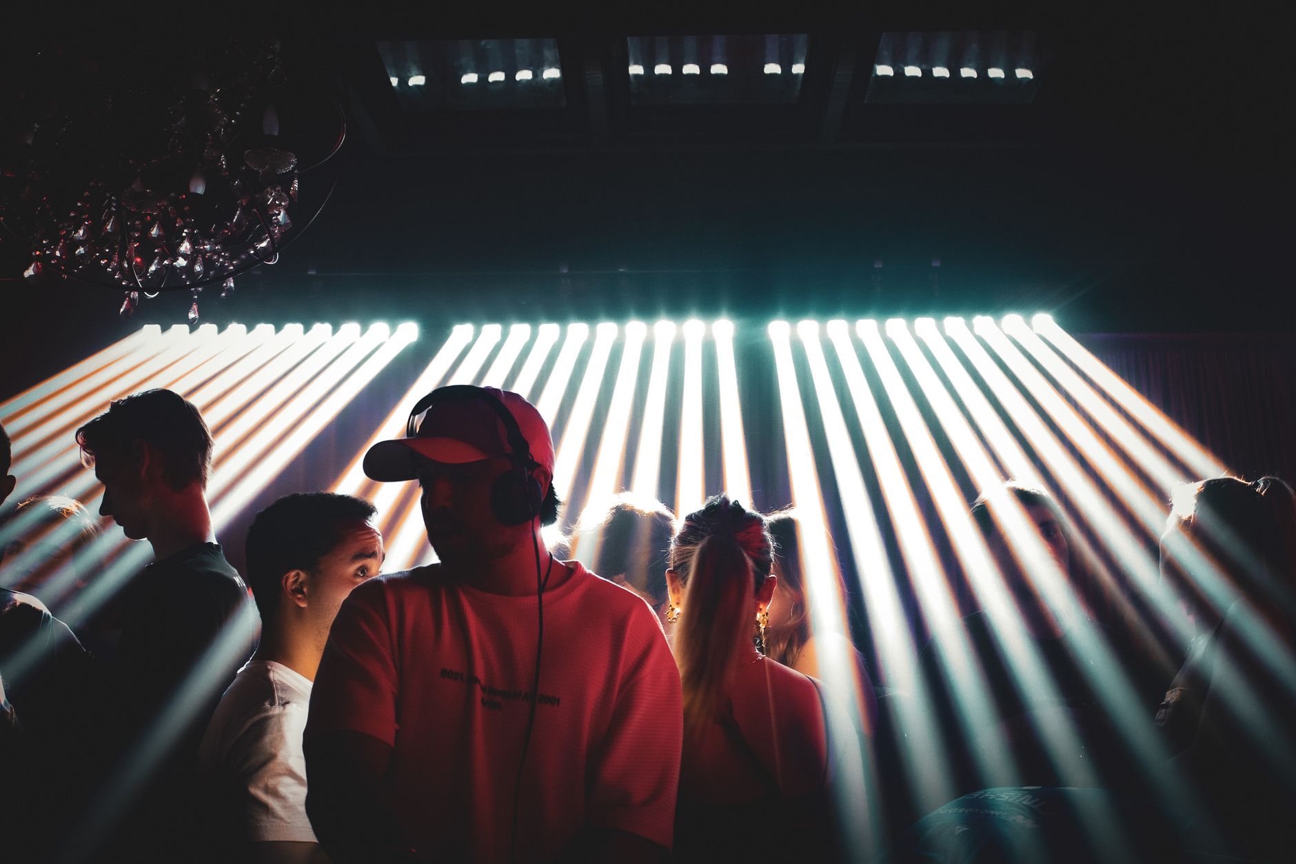 Energetic nightclub setting with people enjoying music and vibrant spotlight effects. Energetic nightclub setting with people enjoying music and vibrant spotlight effects.