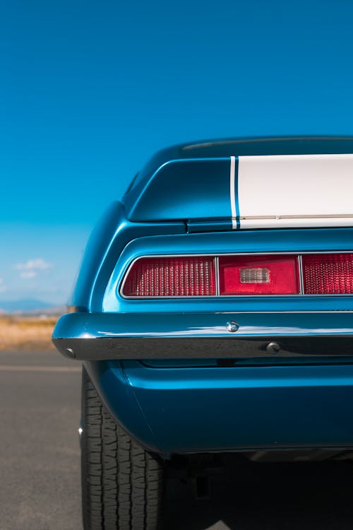 The rear end of a blue and white chevrolet camaro