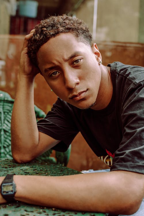 Photo of a Young Man in a Black T-shirt with a Serious Facial Expression 