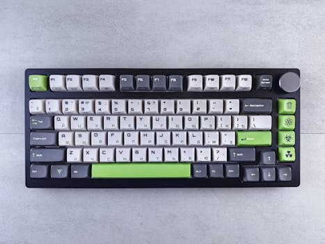 Top view of a modern mechanical keyboard with green accents on a gray surface.