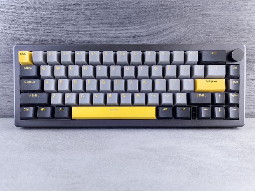 A stylish keyboard featuring gray and yellow keys, perfect for tech and workspace themes.